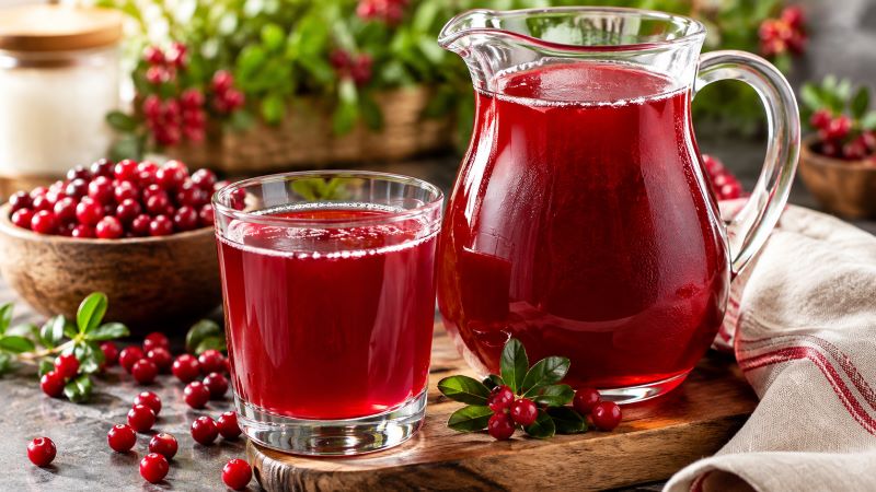 Брусничный морс в графине и стакане, свежие ягоды